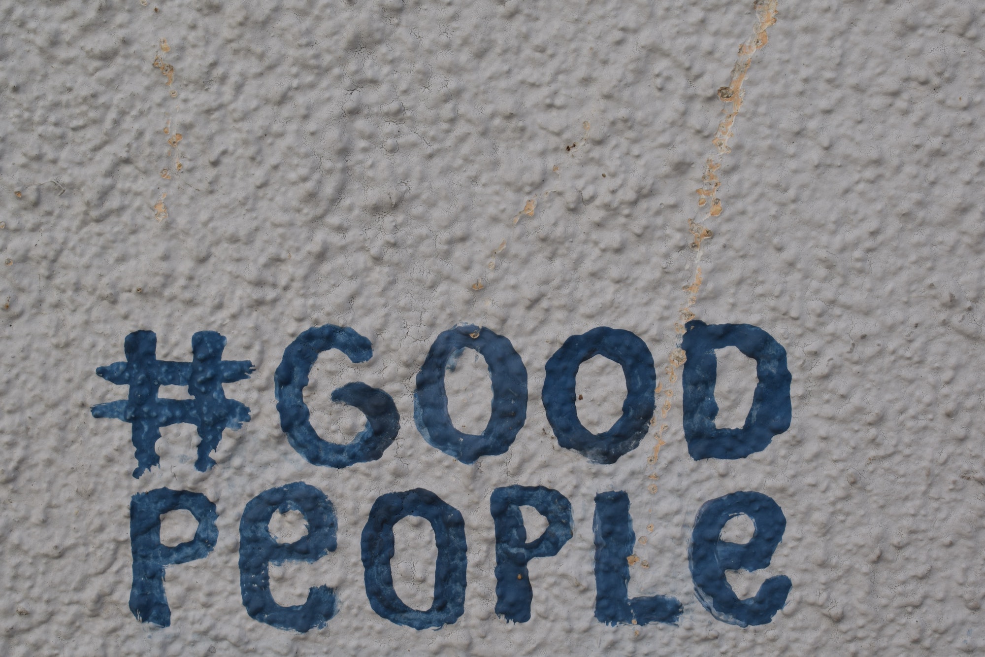 A photo of a wall with good people written on it.
