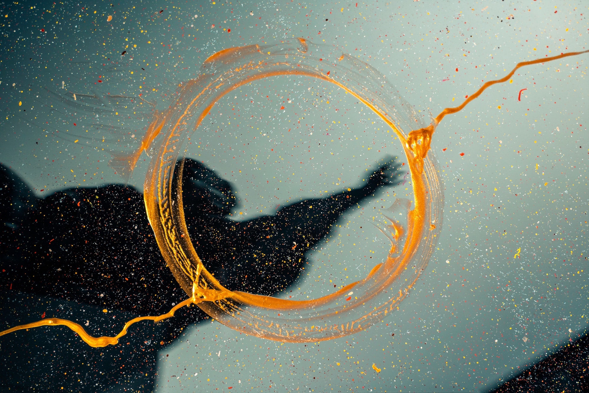 A photo with a golden paint ring and the blurry image of a human in the background.