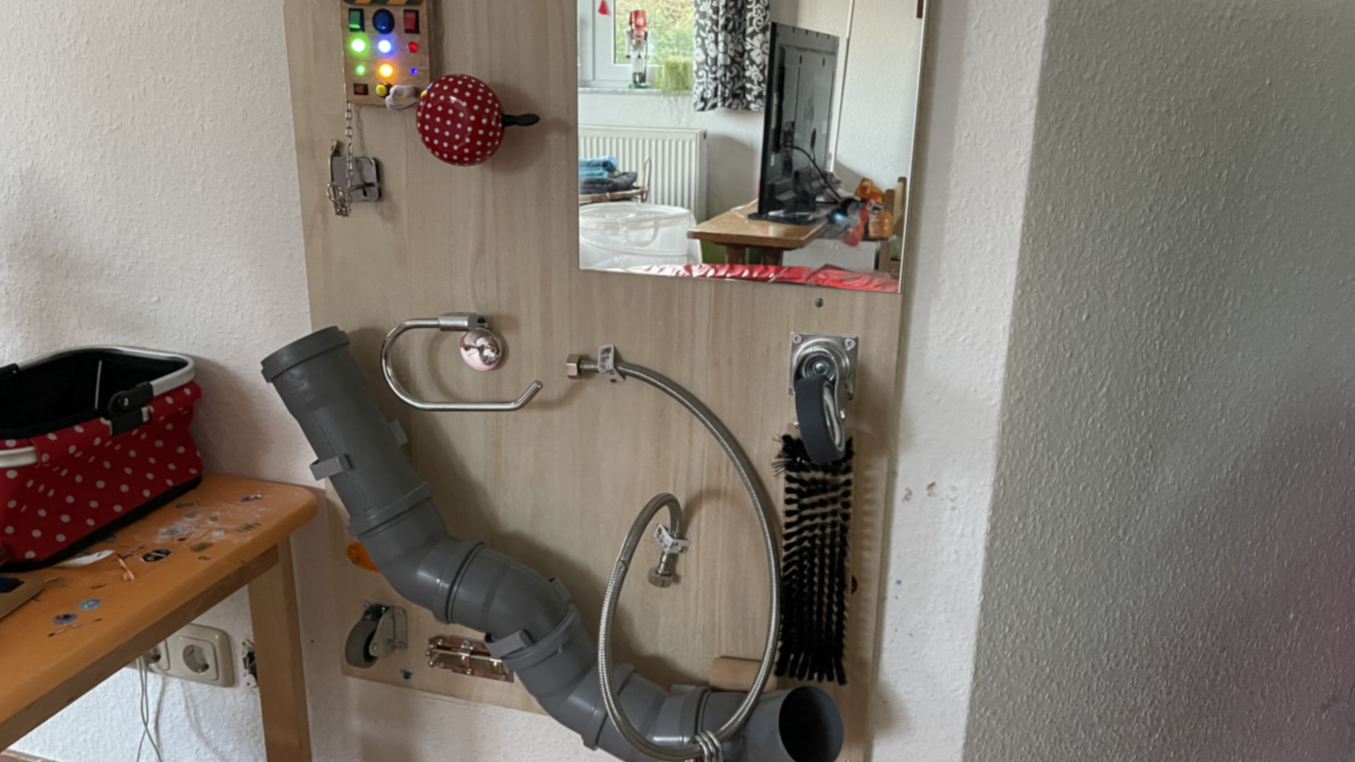 A wall made out of wood with a few fun objects for children to play with